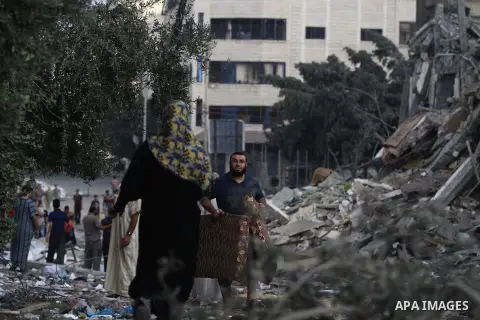 Palestinians collect their belongings from under the rubble of one of Gaza's tallest apartment towers, which witnesses said was hit by an Israeli air strike that destroyed much of it, in Gaza City August 26, 2014. Israel...