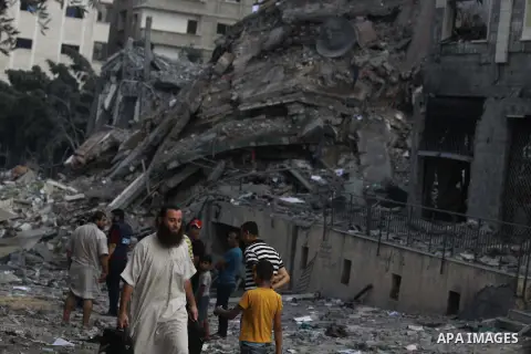 Palestinians gather around the remains of one of Gaza's tallest apartment towers, which witnesses said was hit by an Israeli air strike that destroyed much of it, in Gaza City August 26, 2014. Israeli air strikes launche...