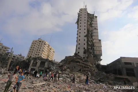 Palestinians gather around the remains of one of Gaza's tallest apartment towers, which witnesses said was hit by an Israeli air strike that destroyed much of it, in Gaza City August 26, 2014. Israeli air strikes launche...