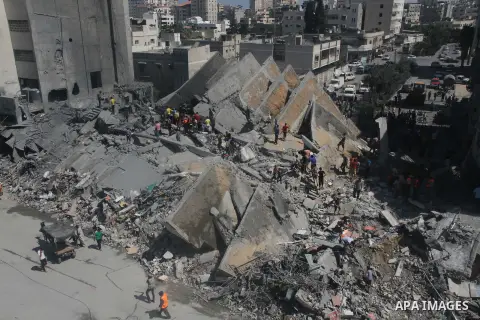 Palestinians gather around the remains of a tower building housing offices which witnesses said was destroyed by an Israeli air strike in Gaza City August 26, 2014. Israeli air strikes launched before dawn on Tuesday kil...