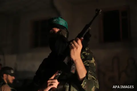 A Palestinian Hamas militant holds his weapon as he celebrate with people what they said was a victory over Israel, following a ceasefire in Gaza City August 26, 2014. A ceasefire agreement between Israel and the Palesti...