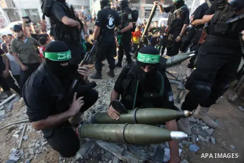 Palestinian militants of Izzedine al-Qassam Brigades, military wing of Hamas, and their supporters celebrate a victory rally at the debris of destroyed houses in Shijaiyah, neighborhood of Gaza City, in the northern Gaza...