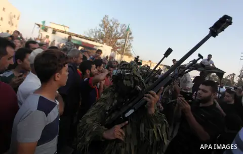 Palestinian militants of Izzedine al-Qassam Brigades, military wing of Hamas, and their supporters celebrate a victory rally at the debris of destroyed houses in Shijaiyah, neighborhood of Gaza City, in the northern Gaza...