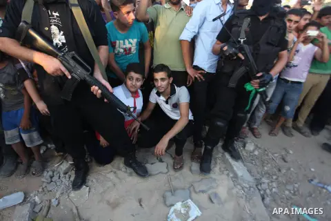 Palestinian militants of Izzedine al-Qassam Brigades, military wing of Hamas, and their supporters celebrate a victory rally at the debris of destroyed houses in Shijaiyah, neighborhood of Gaza City, in the northern Gaza...