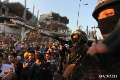 Palestinian militants of Izzedine al-Qassam Brigades, military wing of Hamas, and their supporters celebrate a victory rally at the debris of destroyed houses in Shijaiyah, neighborhood of Gaza City, in the northern Gaza...