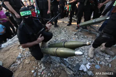 Palestinian militants of Izzedine al-Qassam Brigades, military wing of Hamas, and their supporters celebrate a victory rally at the debris of destroyed houses in Shijaiyah, neighborhood of Gaza City, in the northern Gaza...