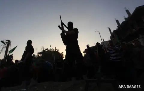 Palestinian militants of Izzedine al-Qassam Brigades, military wing of Hamas, and their supporters celebrate a victory rally at the debris of destroyed houses in Shijaiyah, neighborhood of Gaza City, in the northern Gaza...