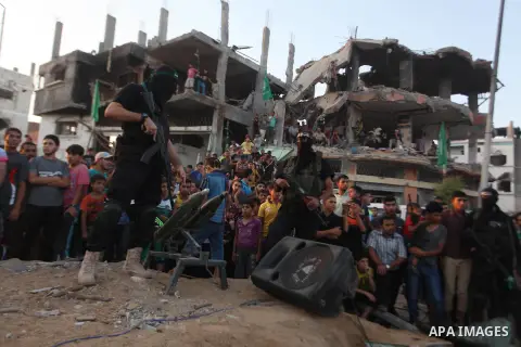 Palestinian militants of Izzedine al-Qassam Brigades, military wing of Hamas, and their supporters celebrate a victory rally at the debris of destroyed houses in Shijaiyah, neighborhood of Gaza City, in the northern Gaza...
