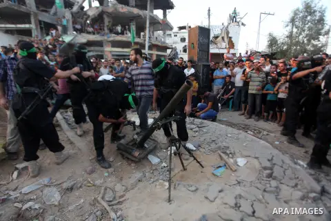 Palestinian militants of Izzedine al-Qassam Brigades, military wing of Hamas, and their supporters celebrate a victory rally at the debris of destroyed houses in Shijaiyah, neighborhood of Gaza City, in the northern Gaza...