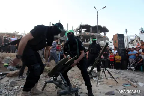 Palestinian militants of Izzedine al-Qassam Brigades, military wing of Hamas, and their supporters celebrate a victory rally at the debris of destroyed houses in Shijaiyah, neighborhood of Gaza City, in the northern Gaza...