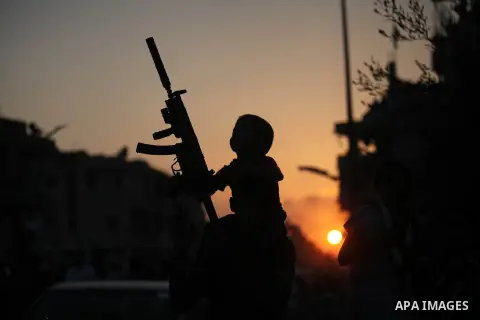 Palestinian militants of Izzedine al-Qassam Brigades, military wing of Hamas, and their supporters celebrate a victory rally at the debris of destroyed houses in Shijaiyah, neighborhood of Gaza City, in the northern Gaza...