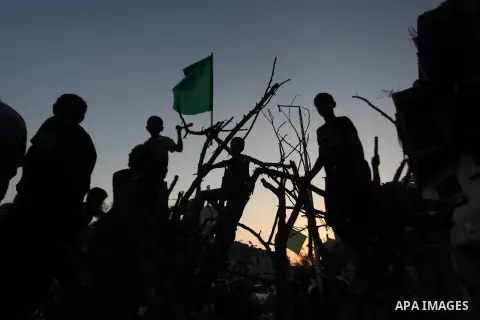 Palestinian militants of Izzedine al-Qassam Brigades, military wing of Hamas, and their supporters celebrate a victory rally at the debris of destroyed houses in Shijaiyah, neighborhood of Gaza City, in the northern Gaza...