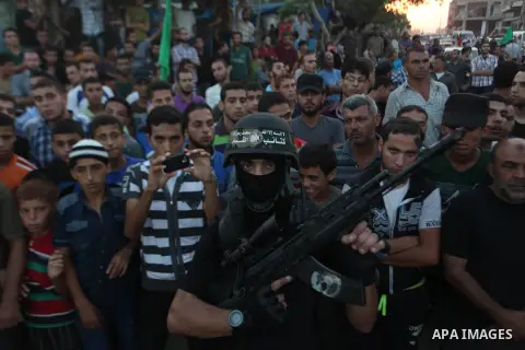 Palestinian militants of Izzedine al-Qassam Brigades, military wing of Hamas, and their supporters celebrate a victory rally at the debris of destroyed houses in Shijaiyah, neighborhood of Gaza City, in the northern Gaza...