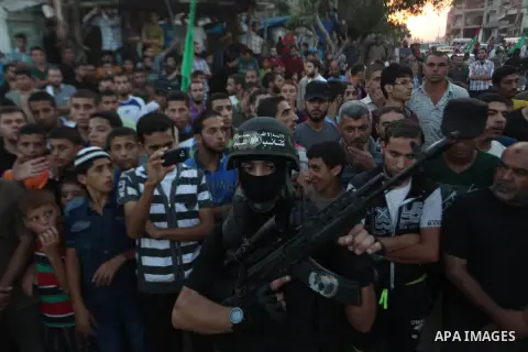 Palestinian militants of Izzedine al-Qassam Brigades, military wing of Hamas, and their supporters celebrate a victory rally at the debris of destroyed houses in Shijaiyah, neighborhood of Gaza City, in the northern Gaza...