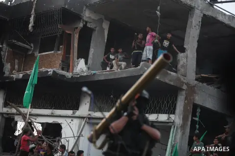 Palestinian militants of Izzedine al-Qassam Brigades, military wing of Hamas, and their supporters celebrate a victory rally at the debris of destroyed houses in Shijaiyah, neighborhood of Gaza City, in the northern Gaza...