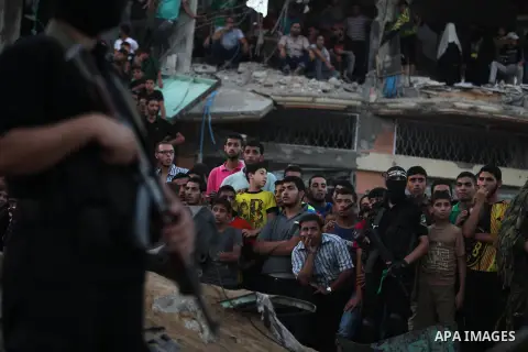 Palestinian militants of Izzedine al-Qassam Brigades, military wing of Hamas, and their supporters celebrate a victory rally at the debris of destroyed houses in Shijaiyah, neighborhood of Gaza City, in the northern Gaza...