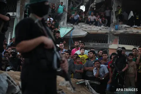 Palestinian militants of Izzedine al-Qassam Brigades, military wing of Hamas, and their supporters celebrate a victory rally at the debris of destroyed houses in Shijaiyah, neighborhood of Gaza City, in the northern Gaza...