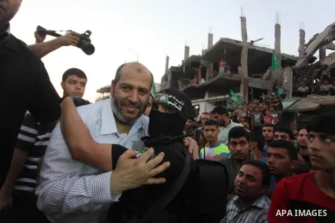 Palestinian militants of Izzedine al-Qassam Brigades, military wing of Hamas, and their supporters celebrate a victory rally at the debris of destroyed houses in Shijaiyah, neighborhood of Gaza City, in the northern Gaza...