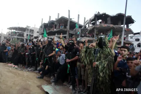 Palestinian militants of Izzedine al-Qassam Brigades, military wing of Hamas, and their supporters celebrate a victory rally at the debris of destroyed houses in Shijaiyah, neighborhood of Gaza City, in the northern Gaza...