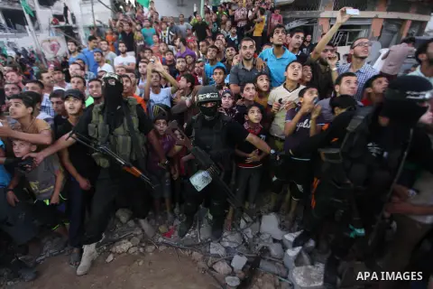 Palestinian militants of Izzedine al-Qassam Brigades, military wing of Hamas, and their supporters celebrate a victory rally at the debris of destroyed houses in Shijaiyah, neighborhood of Gaza City, in the northern Gaza...