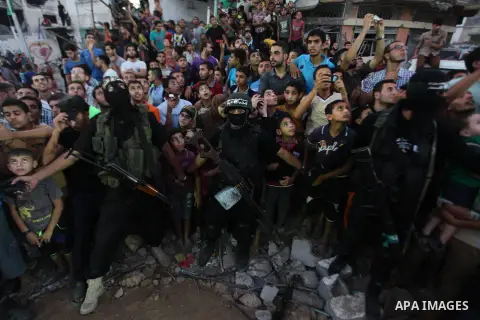 Palestinian militants of Izzedine al-Qassam Brigades, military wing of Hamas, and their supporters celebrate a victory rally at the debris of destroyed houses in Shijaiyah, neighborhood of Gaza City, in the northern Gaza...