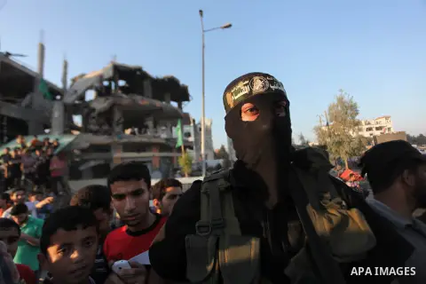Palestinian militants of Izzedine al-Qassam Brigades, military wing of Hamas, and their supporters celebrate a victory rally at the debris of destroyed houses in Shijaiyah, neighborhood of Gaza City, in the northern Gaza...