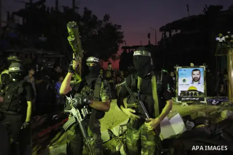 Palestinian militants of Izzedine al-Qassam Brigades, military wing of Hamas, and their supporters celebrate a victory rally at the debris of destroyed houses in Shijaiyah, neighborhood of Gaza City, in the northern Gaza...