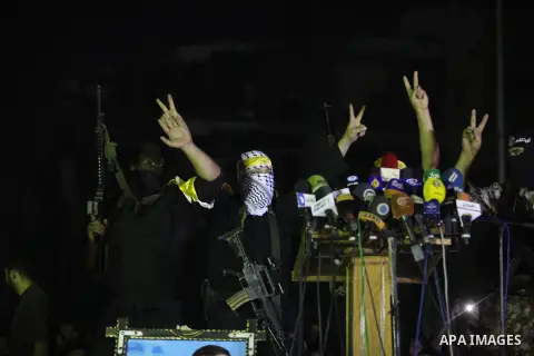 Palestinian militants of Izzedine al-Qassam Brigades, military wing of Hamas, and their supporters celebrate a victory rally at the debris of destroyed houses in Shijaiyah, neighborhood of Gaza City, in the northern Gaza...