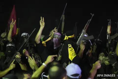 Palestinian militants of Izzedine al-Qassam Brigades, military wing of Hamas, and their supporters celebrate a victory rally at the debris of destroyed houses in Shijaiyah, neighborhood of Gaza City, in the northern Gaza...