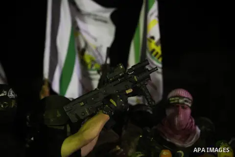 Palestinian militants of Izzedine al-Qassam Brigades, military wing of Hamas, and their supporters celebrate a victory rally at the debris of destroyed houses in Shijaiyah, neighborhood of Gaza City, in the northern Gaza...