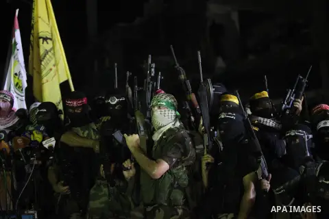 Palestinian militants of Izzedine al-Qassam Brigades, military wing of Hamas, and their supporters celebrate a victory rally at the debris of destroyed houses in Shijaiyah, neighborhood of Gaza City, in the northern Gaza...