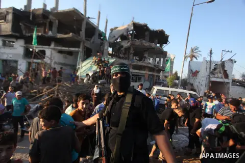 Palestinian militants of Izzedine al-Qassam Brigades, military wing of Hamas, and their supporters celebrate a victory rally at the debris of destroyed houses in Shijaiyah, neighborhood of Gaza City, in the northern Gaza...