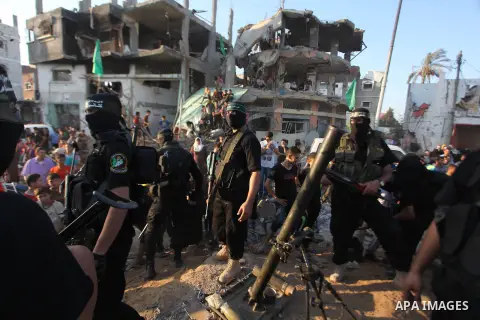 Palestinian militants of Izzedine al-Qassam Brigades, military wing of Hamas, and their supporters celebrate a victory rally at the debris of destroyed houses in Shijaiyah, neighborhood of Gaza City, in the northern Gaza...