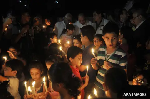 Palestinian Families hold candles during a protest in front of the remains El Zafer Tower destroyed in an israeli airstrike, in Gaza city, on Aug. 27, 2014. The open-ended ceasefire in the Gaza war between Israel and the...