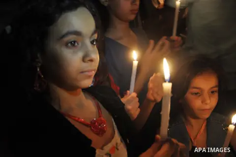 Palestinian Families hold candles during a protest in front of the remains El Zafer Tower destroyed in an israeli airstrike, in Gaza city, on Aug. 27, 2014. The open-ended ceasefire in the Gaza war between Israel and the...