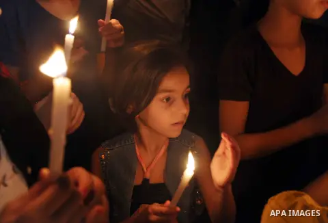 Palestinian Families hold candles during a protest in front of the remains El Zafer Tower destroyed in an israeli airstrike, in Gaza city, on Aug. 27, 2014. The open-ended ceasefire in the Gaza war between Israel and the...
