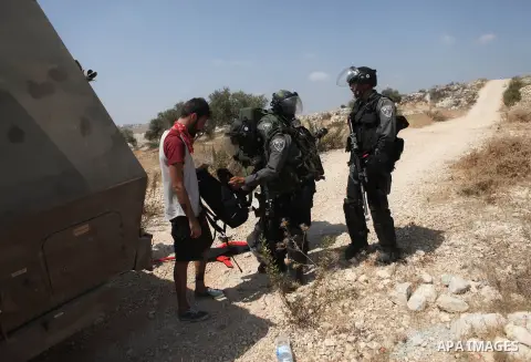 Members of the Israeli security forces arrest an Israeli demonstrating in solidarity with Palestinian protestors in the village of Bilin, near the West Bank city of Ramallah following a march in support of the resistance...