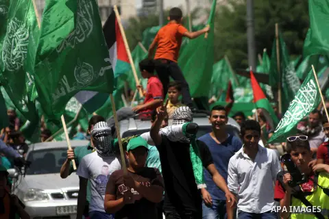 Palestinians wave Hamas and Palestinian flags during a rally following the Friday prayers, three days after a deal hailed by Israel and Hamas as 'victory' in the 50-day war on August 29, 2014 in the West Bank town of Heb...