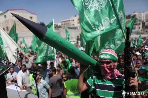 A masked Palestinian boy holds a mock rocket during a rally following the Friday prayers, three days after a deal hailed by Israel and Hamas as 'victory' in the 50-day war on August 29, 2014 in the West Bank town of Hebr...