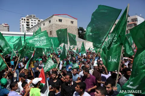 Palestinians wave Hamas and Palestinian flags during a rally following the Friday prayers, three days after a deal hailed by Israel and Hamas as 'victory' in the 50-day war on August 29, 2014 in the West Bank town of Heb...
