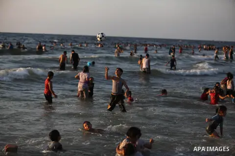 Palestinians swim in the Mediterranean Sea off the coast of Gaza City August 29, 2014, days after a ceasefire was reached. An open-ended ceasefire, mediated by Egypt, took effect on Tuesday evening. It called for an inde...