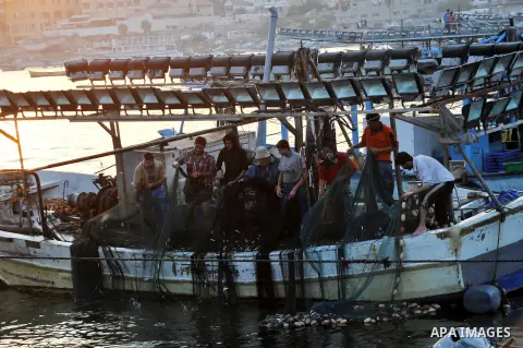 Palestinian fishermen clean their boats at Gaza's seaport in Gaza City early on August 29, 2014. Israel and Hamas accepted an Egyptian proposal for a long-term ceasefire in war-torn Gaza on August 26 in a move to end 50...