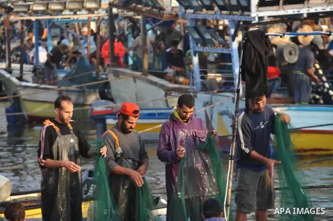 Palestinian fishermen clean their boats at Gaza's seaport in Gaza City early on August 29, 2014. Israel and Hamas accepted an Egyptian proposal for a long-term ceasefire in war-torn Gaza on August 26 in a move to end 50...