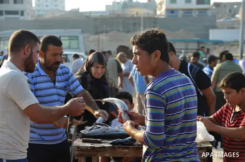 A Palestinian fisherman sells fish at Gaza's seaport in Gaza City early on August 29, 2014. Israel and Hamas accepted an Egyptian proposal for a long-term ceasefire in war-torn Gaza on August 26 in a move to end 50 days...
