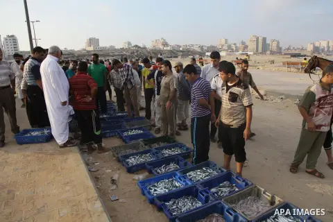 A Palestinian fisherman sells fish at Gaza's seaport in Gaza City early on August 29, 2014. Israel and Hamas accepted an Egyptian proposal for a long-term ceasefire in war-torn Gaza on August 26 in a move to end 50 days...