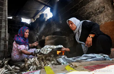 Palestinian women bake bread on the rubble of their house which witnesses said was destroyed during the Israeli offensive in Shejaiya neighborhood after a ceasefire was declared, in Gaza city on August 30, 2014. An open-...