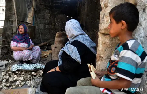 Palestinian women bake bread on the rubble of their house which witnesses said was destroyed during the Israeli offensive in Shejaiya neighborhood after a ceasefire was declared, in Gaza city on August 30, 2014. An open-...