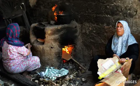 Palestinian women bake bread on the rubble of their house which witnesses said was destroyed during the Israeli offensive in Shejaiya neighborhood after a ceasefire was declared, in Gaza city on August 30, 2014. An open-...