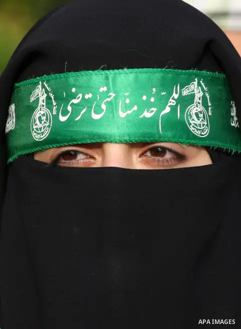 A masked Palestinian woman takes part in a rally showing their support and solidarity with Hamas in the West Bank city of Tulkarem, 30 August 2014. An indefinite ceasefire to end seven weeks of fighting between Israel an...