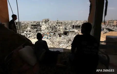 Palestinians sit on a sofa at their house which destroyed during fighting between Hamas militants and Israel in the Al-Shaaf neighbourhood, in Gaza City, on August 31, 2014. An indefinite ceasefire to end seven weeks of...